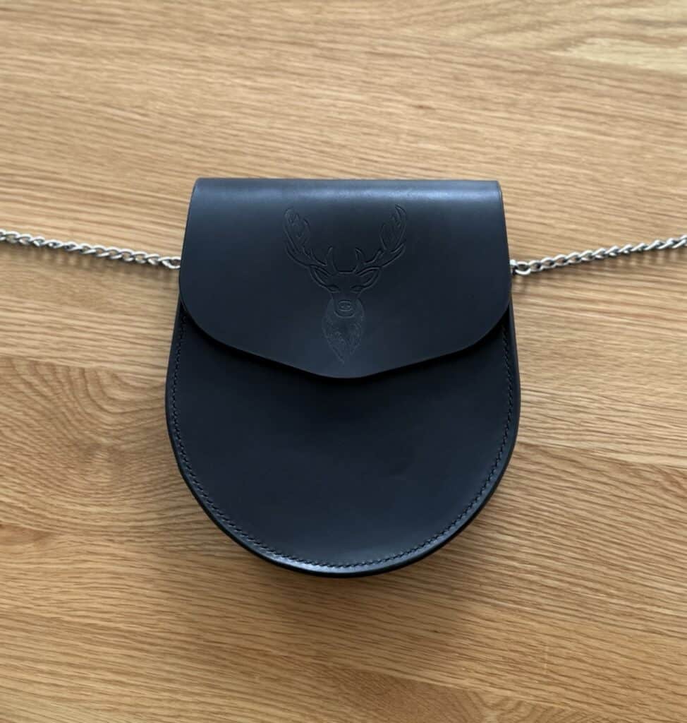 Black leather sporran with hand-tooled design of a stag, handcrafted by Kate Robertson